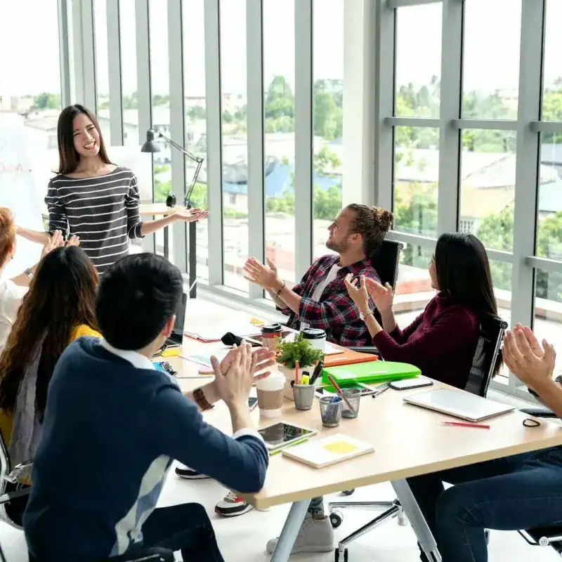 Facilitator presenting a workplace initiative program overview to a small group in a meeting room